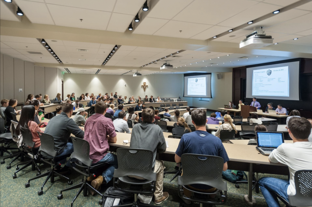 Image of a lecture hall full of students. Over the image reads, "ELL Workshop. TBD"